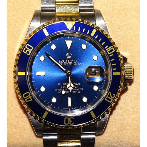 Rolex, a bi-metal Submariner Oyster Perpetual Date bracelet wrist watch ref: 16613, the blue dial with dot, baton and triangular hour markers, sweep centre seconds, date aperture at '3', Rolex crown and rotating dark blue bezel, serial number T818145, case 40mm, boxed with papers dated 24-6-97, outer box with plastic tags, spare link and Rolex Oyster anchor, (superficial scratches).