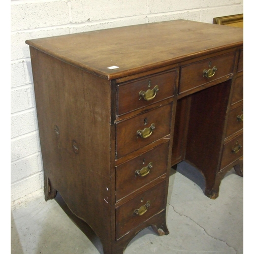 3 - A George III mahogany kneehole desk fitted with nine small drawers, (damaged), around a central cupb... 