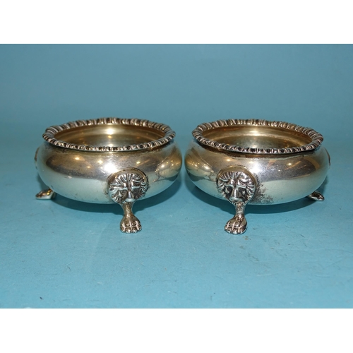 613 - A pair of Hukin & Heath salts with lion masks, on paw feet, 7cm diameter, London 1931 and Birmin... 