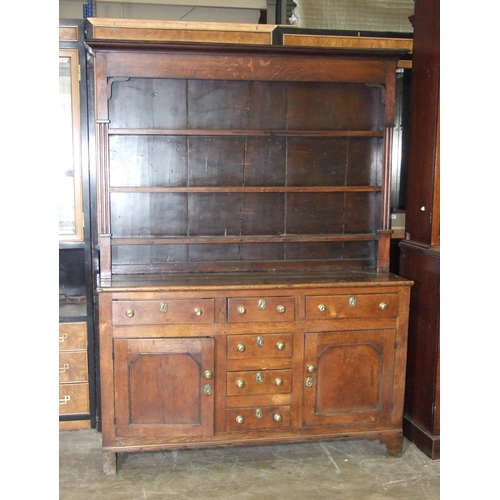 8 - A Georgian oak dresser, the later plate rack above three frieze drawers, three central small drawers... 