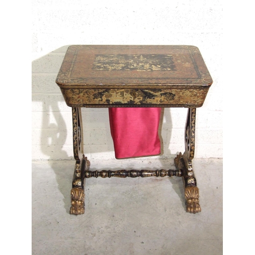 32 - A Victorian lacquered work table with fitted interior and pull-out work bag, on end supports and gil... 