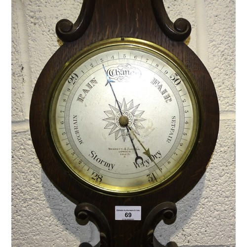 69 - A Negretti and Zambra aneroid wheel barometer and thermometer in oak case, 93cm high.... 