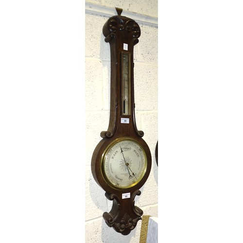 69 - A Negretti and Zambra aneroid wheel barometer and thermometer in oak case, 93cm high.... 