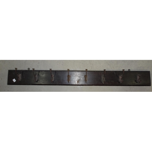 79 - A set of eight metal hat and coat hooks (all af), on a rectangular wood base, 50.5 x 14cm, a walnut ... 