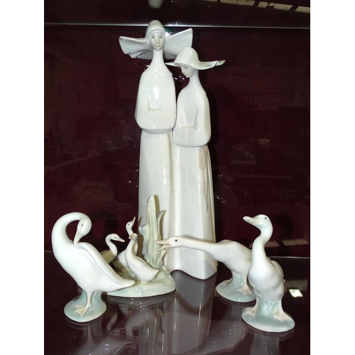 27 - Lladro, a figurine depicting two nuns in habits, Lladro back stamp and impressed marks to base, 34cm... 