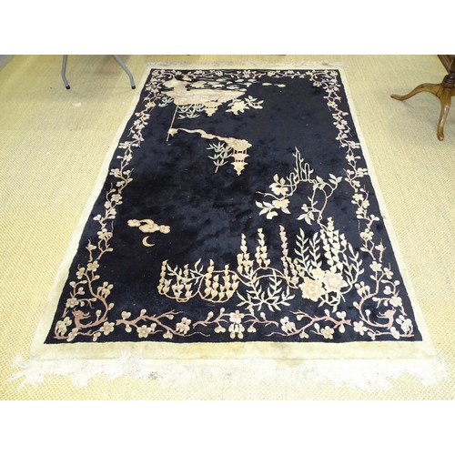 14 - A Chinese rug decorated with prunus on a black ground, 270 x 170cm.