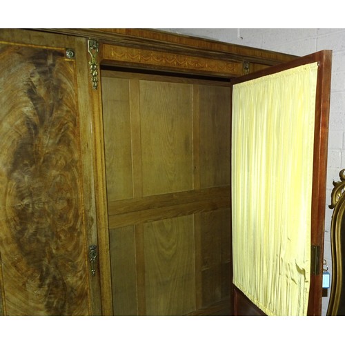 44 - A late-19th century French walnut cross-banded three-door wardrobe, the central door with silk-lined... 