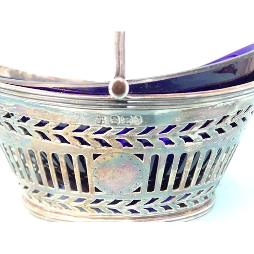 365 - A late-Victorian silver swing-handled sugar basket with pierced decoration and blue glass liner (chi... 