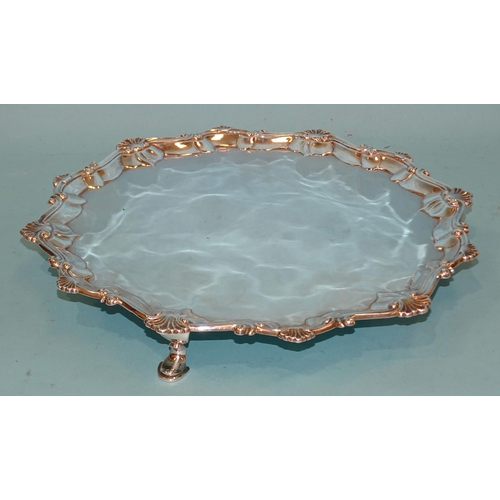 390 - A George III silver salver with waved shell and scroll border, on three hoof feet, 33cm diameter, Lo... 