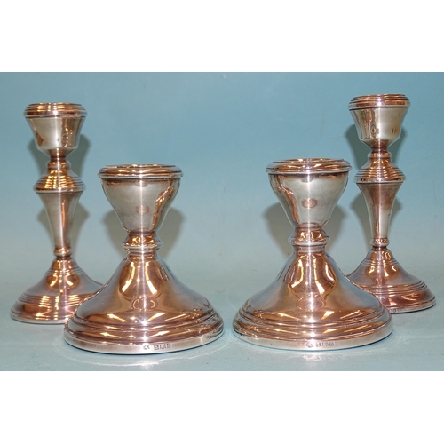 401 - A pair of short silver candlesticks with loaded bases, 10cm high, Birmingham 1960 and a later pair, ... 