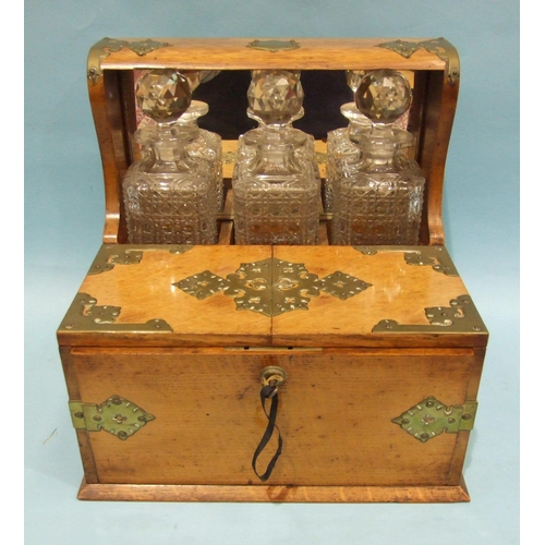 72 - A Victorian/Edwardian Tantalus and games compendium fitted with three decanters, original matching g... 