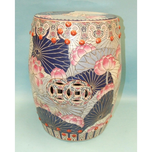 85 - A 20th century Oriental ceramic garden seat of barrel shape decorated with peonies in pastel blues, ... 