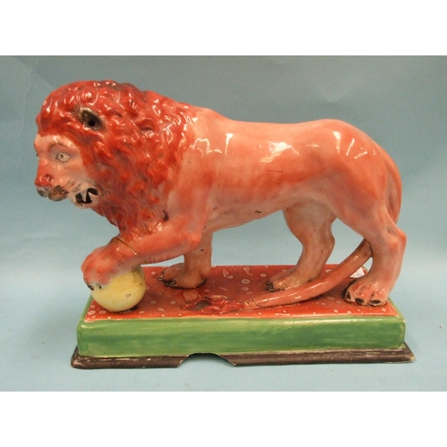 95 - An early Staffordshire model of a Medici lion, with left paw on a globe, on oblong plinth, 31cm long... 