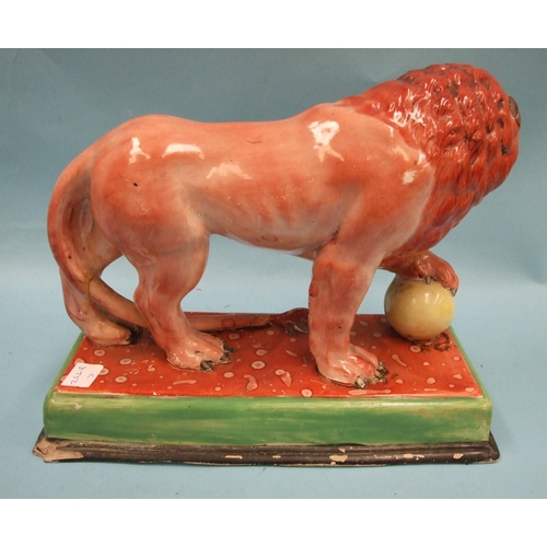 95 - An early Staffordshire model of a Medici lion, with left paw on a globe, on oblong plinth, 31cm long... 