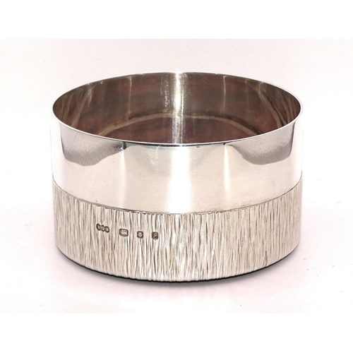 452 - Gerald Benney CBE, a Modernist silver bottle coaster, the lower half with 'bark' texture, 5.5cm high... 