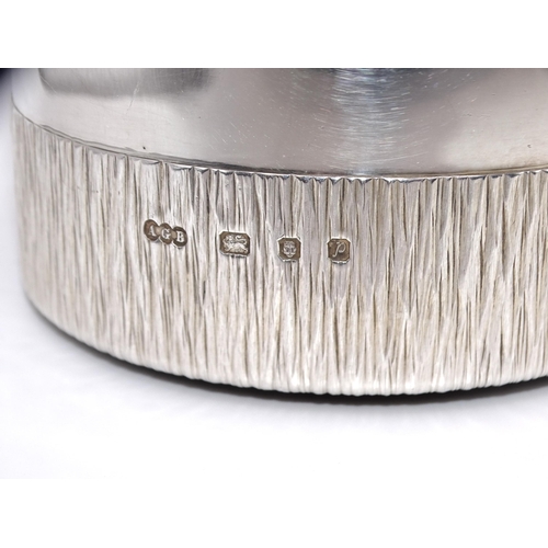 452 - Gerald Benney CBE, a Modernist silver bottle coaster, the lower half with 'bark' texture, 5.5cm high... 