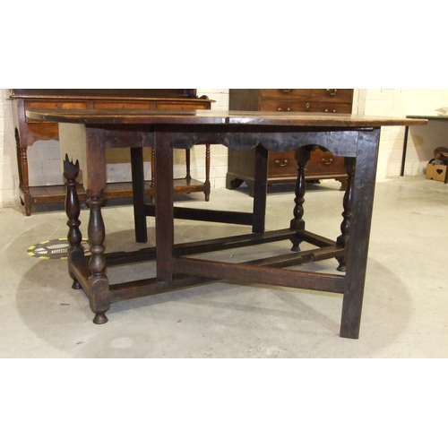 51 - A large antique oak oval gate-leg dining table on turned legs joined by stretchers, 156 x 163cm open... 