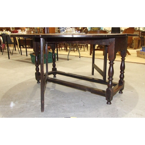 51 - A large antique oak oval gate-leg dining table on turned legs joined by stretchers, 156 x 163cm open... 