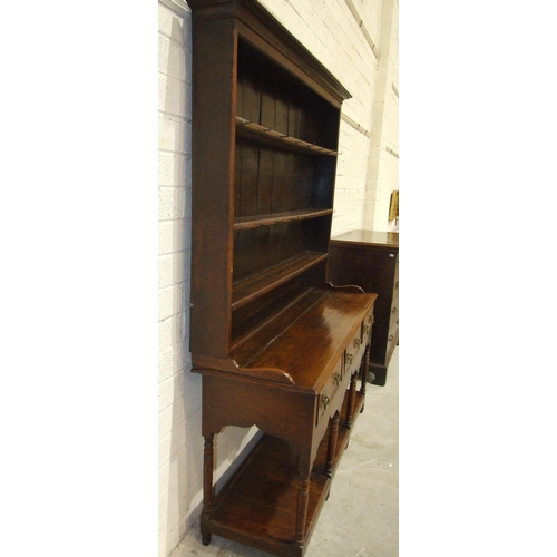 62 - An 18th century oak dresser with three-shelf plate rack, the base with three drawers, on turned supp... 