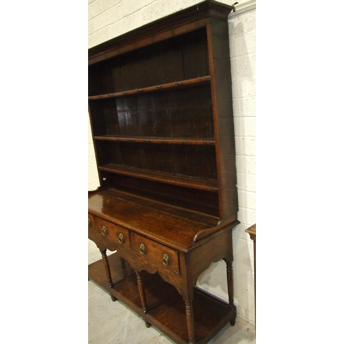 62 - An 18th century oak dresser with three-shelf plate rack, the base with three drawers, on turned supp... 