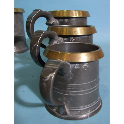 108 - Three graduated pewter and brass-rimmed measures with ER and GR marks, 14cm, 10.5cm and 8cm high and... 