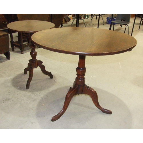 50 - An antique oak country circular tripod table on turned column and shaped legs, 53cm diameter and a l... 