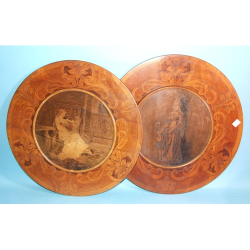 75 - A pair of pokerwork wood circular chargers decorated with a young woman and child, each signed in po... 