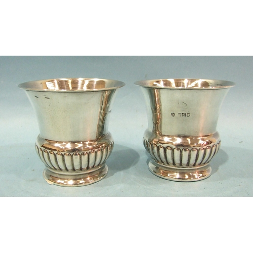 429 - A pair of Edwardian silver small vases with flared rims and half-gadrooned base, 7.5cm high, London ... 