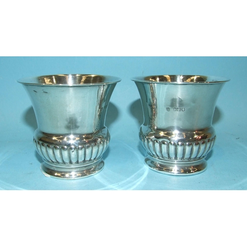 429 - A pair of Edwardian silver small vases with flared rims and half-gadrooned base, 7.5cm high, London ... 