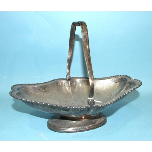 431 - A George V silver swing-handled bowl of shaped lozenge design with beaded edge, on oval foot, 27 x 2... 