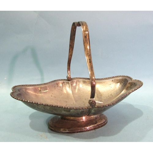 431 - A George V silver swing-handled bowl of shaped lozenge design with beaded edge, on oval foot, 27 x 2... 