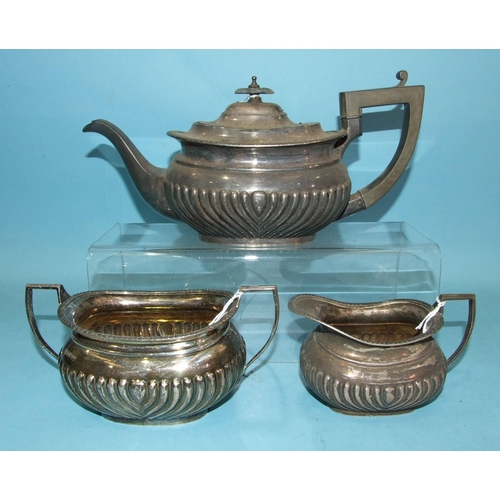 432 - A George V silver three-piece tea service with gadrooned decoration, comprising: teapot, sugar bowl ... 