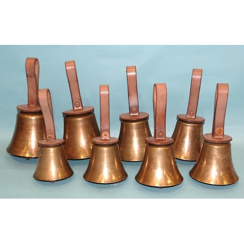 321 - A set of eight campanology hand bells with leather handles.