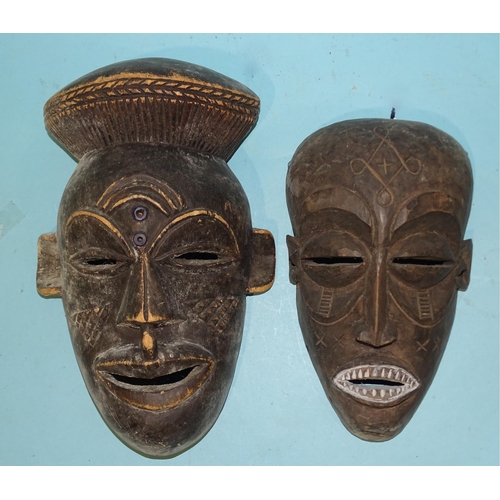 462 - Two carved hardwood 20th century tribal masks, 30cm and 25cm, one with modern label marked TCHOKEE, ... 