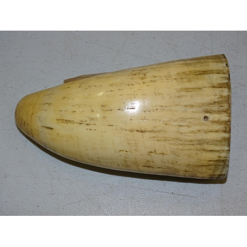 375 - A 19th century scrimshaw tooth depicting a single-masted gaff-rigged vessel, 12.5cm long.... 