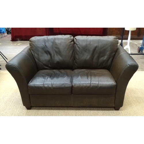 1 - A two-seater sofa with high sides and dark brown leather upholstery, with matching seat and back cus... 