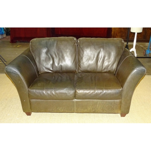 1 - A two-seater sofa with high sides and dark brown leather upholstery, with matching seat and back cus... 