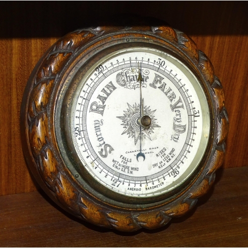 55 - A circular aneroid barometer by Casartelli Bros, Liverpool, in wood rope-twist surround, 19cm diamet... 