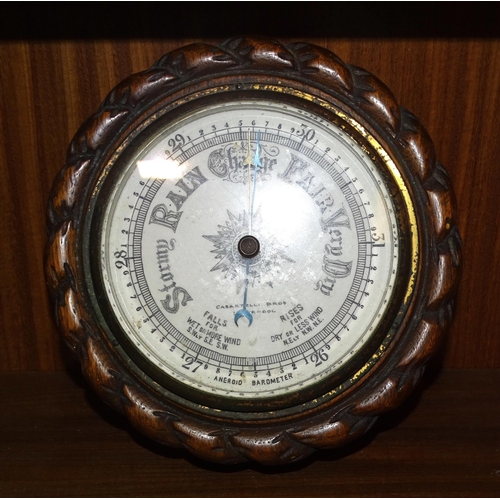 55 - A circular aneroid barometer by Casartelli Bros, Liverpool, in wood rope-twist surround, 19cm diamet... 