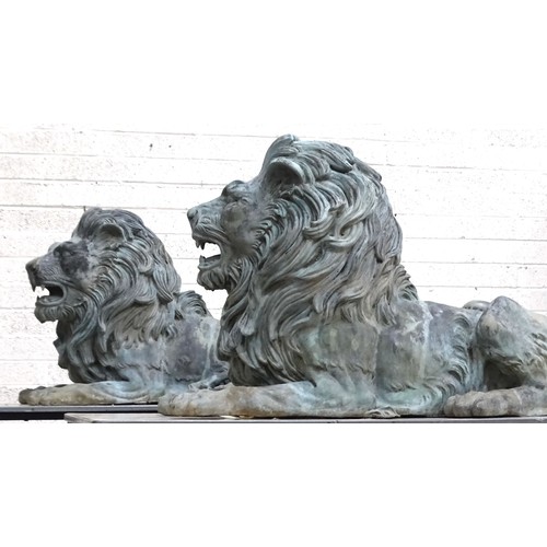 An impressive and large pair of cast metal and coppered lions, each recumbent lion with open mouth, 120cm long, 74cm high, 50cm wide approximately.