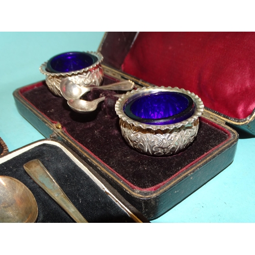 145 - A pair of Victorian silver salts with embossed decoration, 5cm diameter, 3cm high, with associated g... 