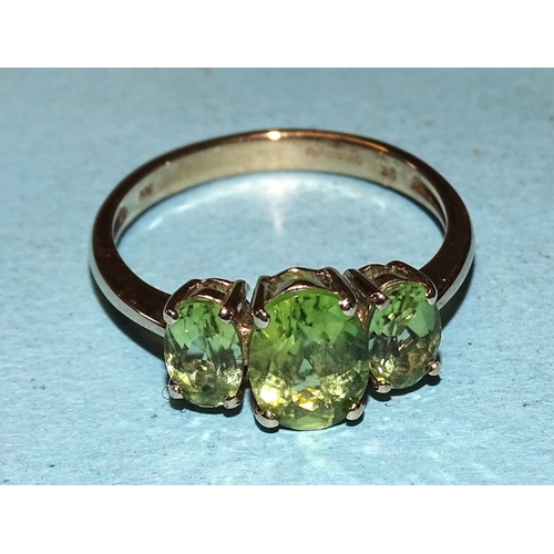 397 - A 9ct gold ring set three oval peridots, size O, 2.4g.