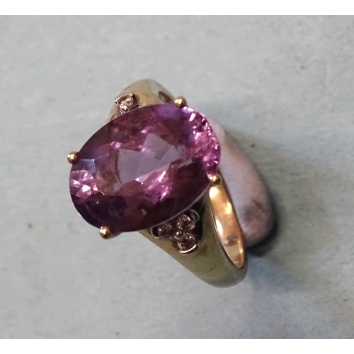 412 - A 9ct gold ring set an oval amethyst between diamond-set shoulders, (amethyst chipped), size O, 3.9g... 