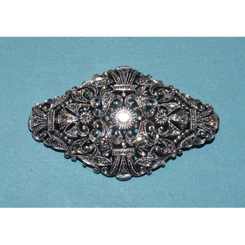 413 - A late-19th century silver and gold plaque brooch set old brilliant and rose-cut diamonds, in a scro... 