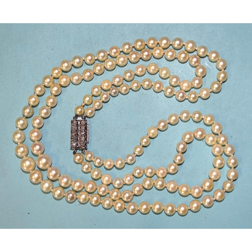 446 - A necklace of two strings of graduated cultured pearls, with 14ct white gold clasp set two lines, ea... 