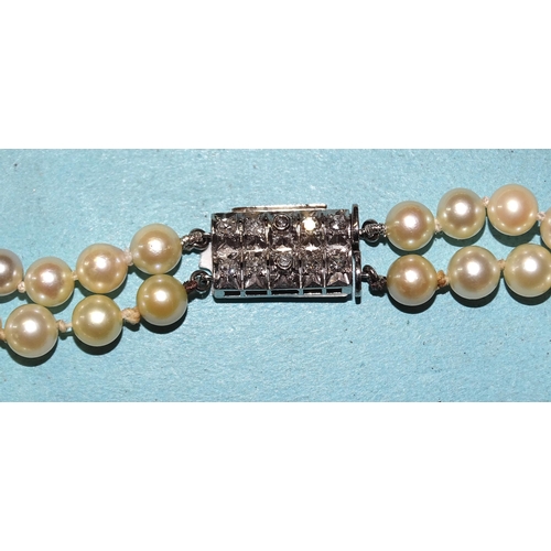 446 - A necklace of two strings of graduated cultured pearls, with 14ct white gold clasp set two lines, ea... 