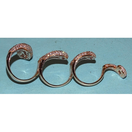 451 - An impressive four-finger ring in the form of a snake pavé-set white diamonds interspersed wi... 