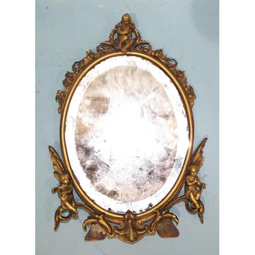 99 - An early-20th century gilt-brass oval strut mirror, the foliate frame applied with three cherubs, 25... 