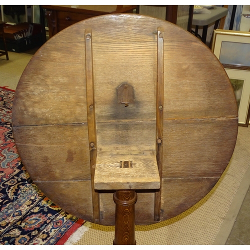 74 - A 19th century oak circular tilt-top table, on turned column and triform support, 73.5cm diameter.... 