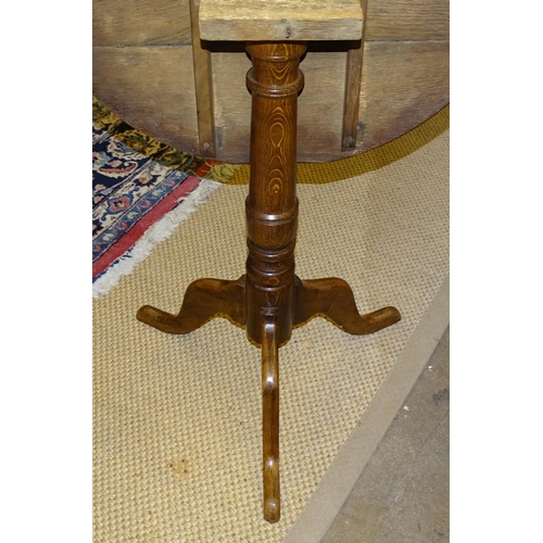 74 - A 19th century oak circular tilt-top table, on turned column and triform support, 73.5cm diameter.... 